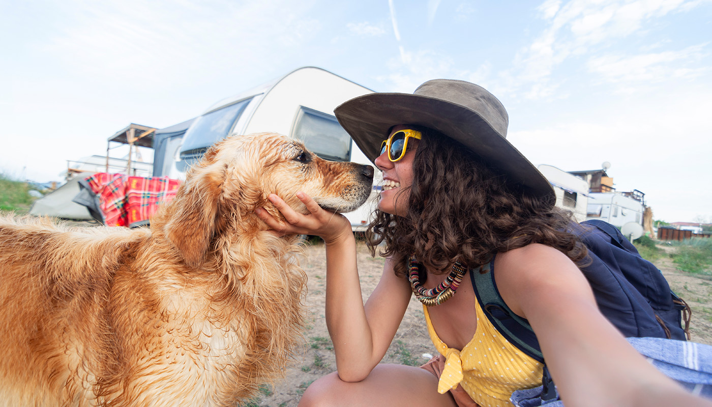 Young woman in summer wardrobe taking a selfie with her Golden Retriever