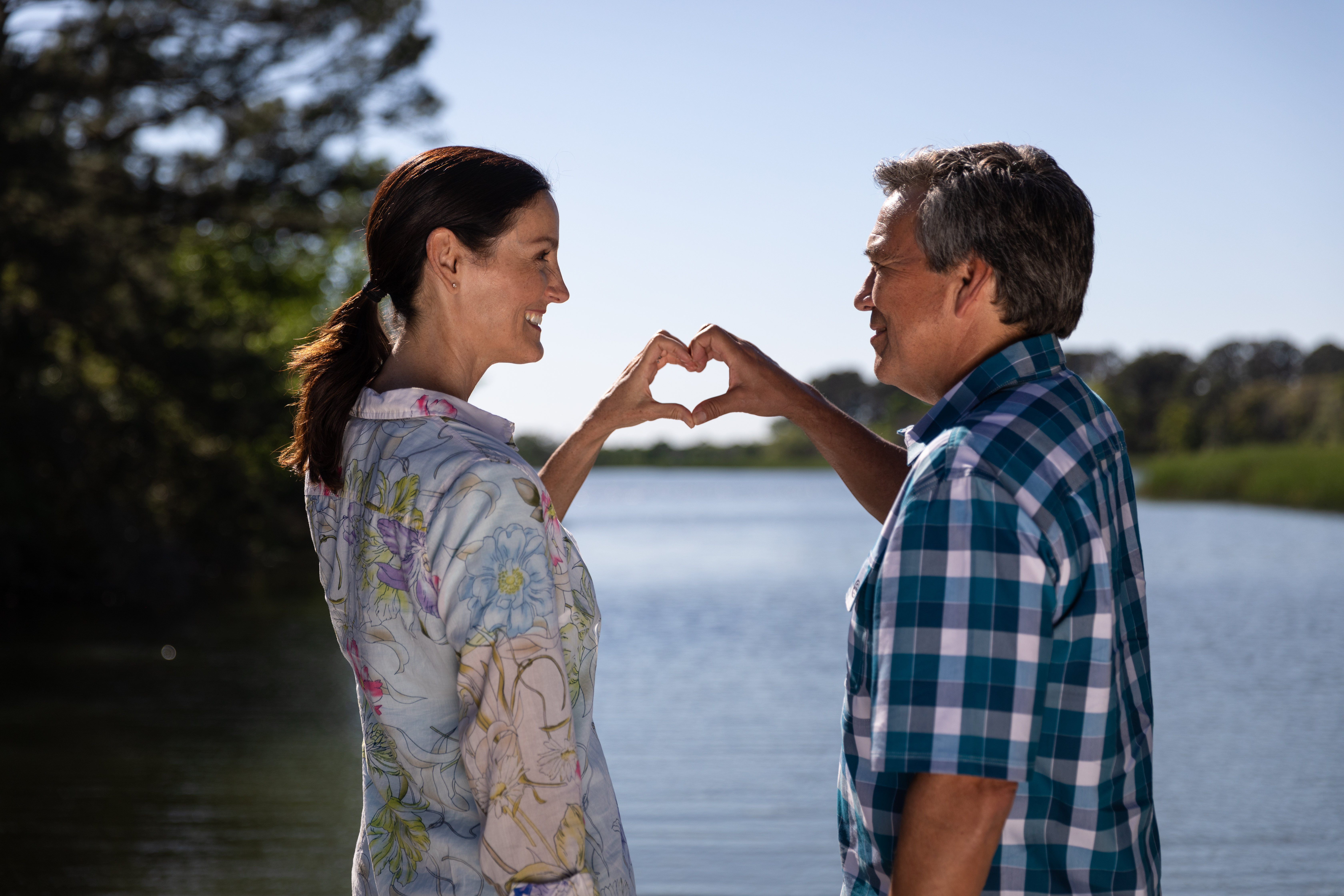 A couple holding hands together to make a heart shape