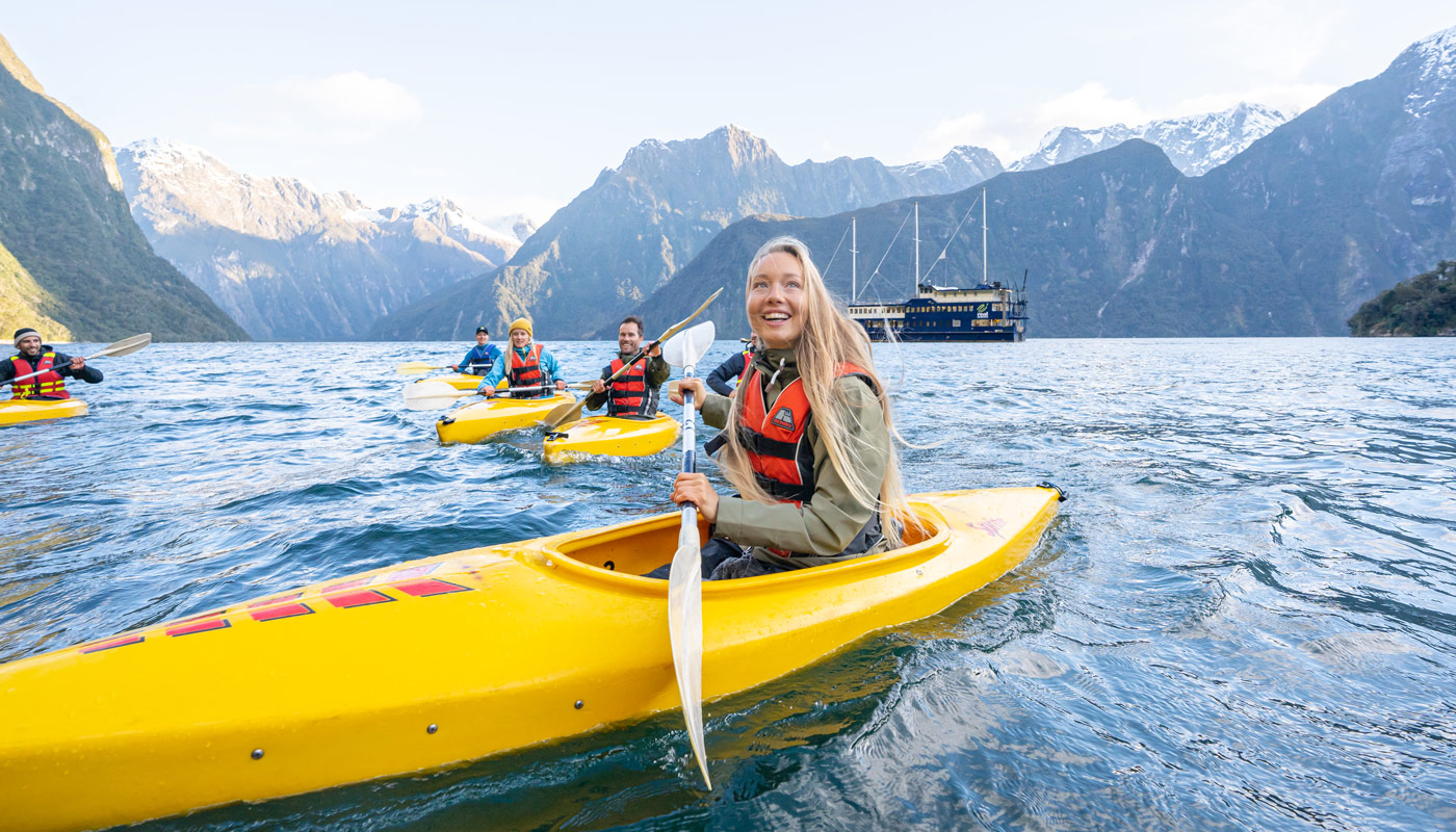 Woman in a yellow kayak with fellow kayakers nearby.