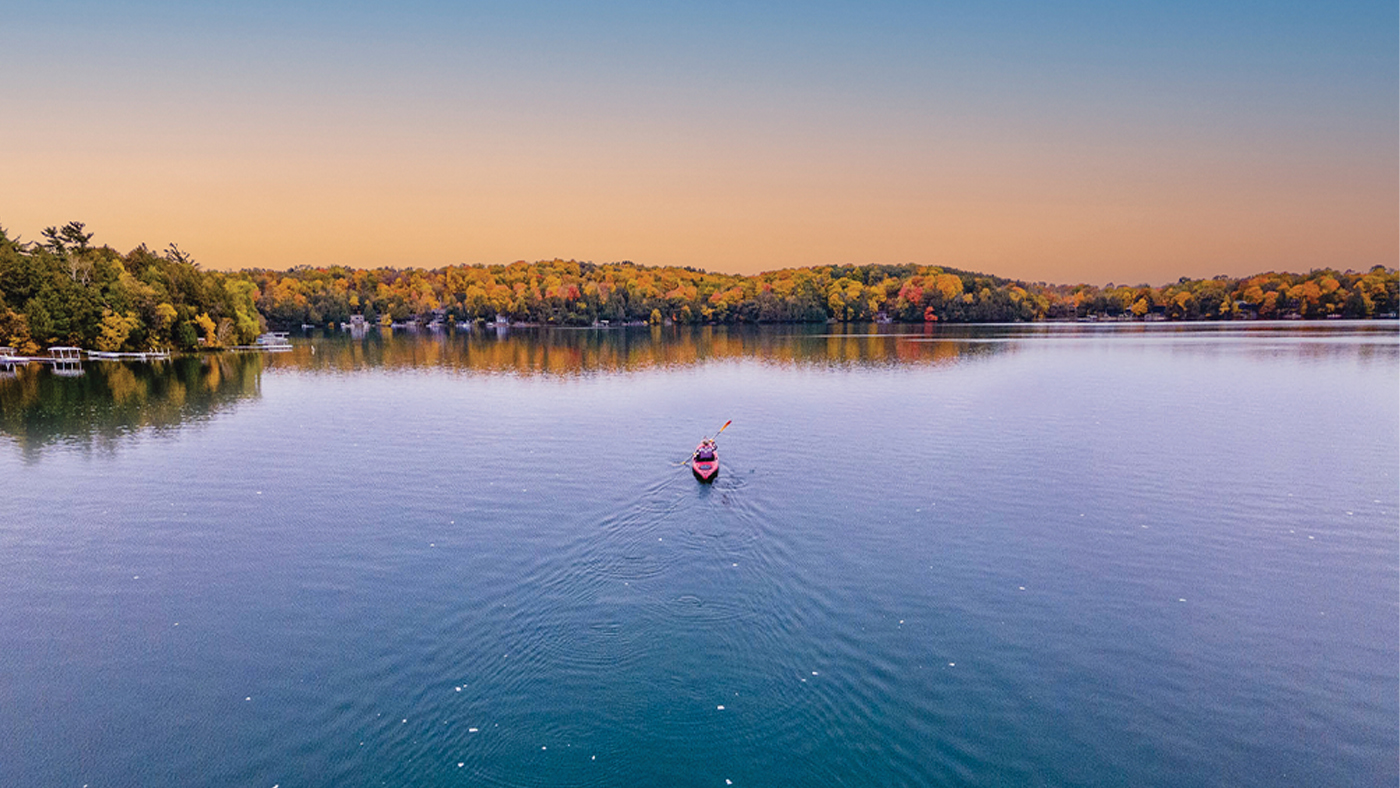 A person in a kayak at sunset on Elkhart Lake.