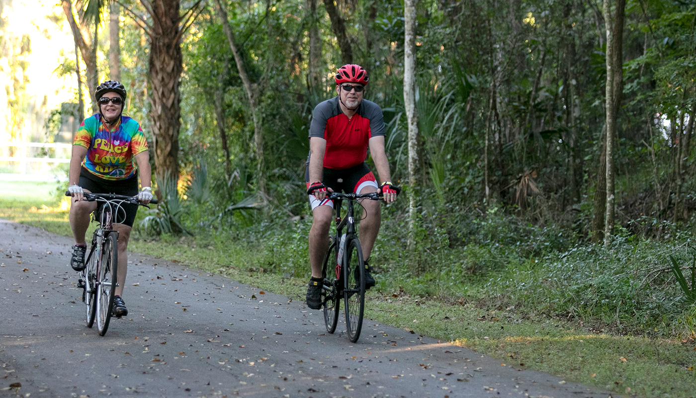 Two adults on bicycles on the Good Neighbor Trail in Brooksville, FL.