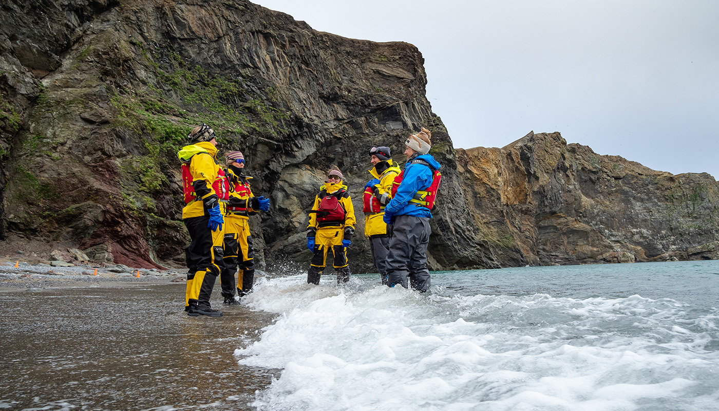 Hurtigruten expedition team of adults standing in surf