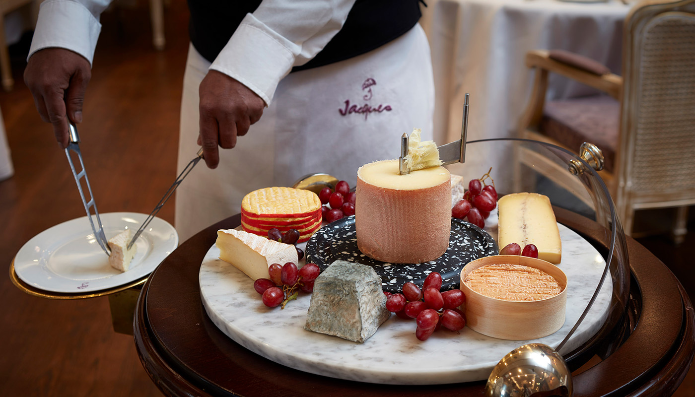 Waiter serving cheese from cheese trolley in Jacques restaurant