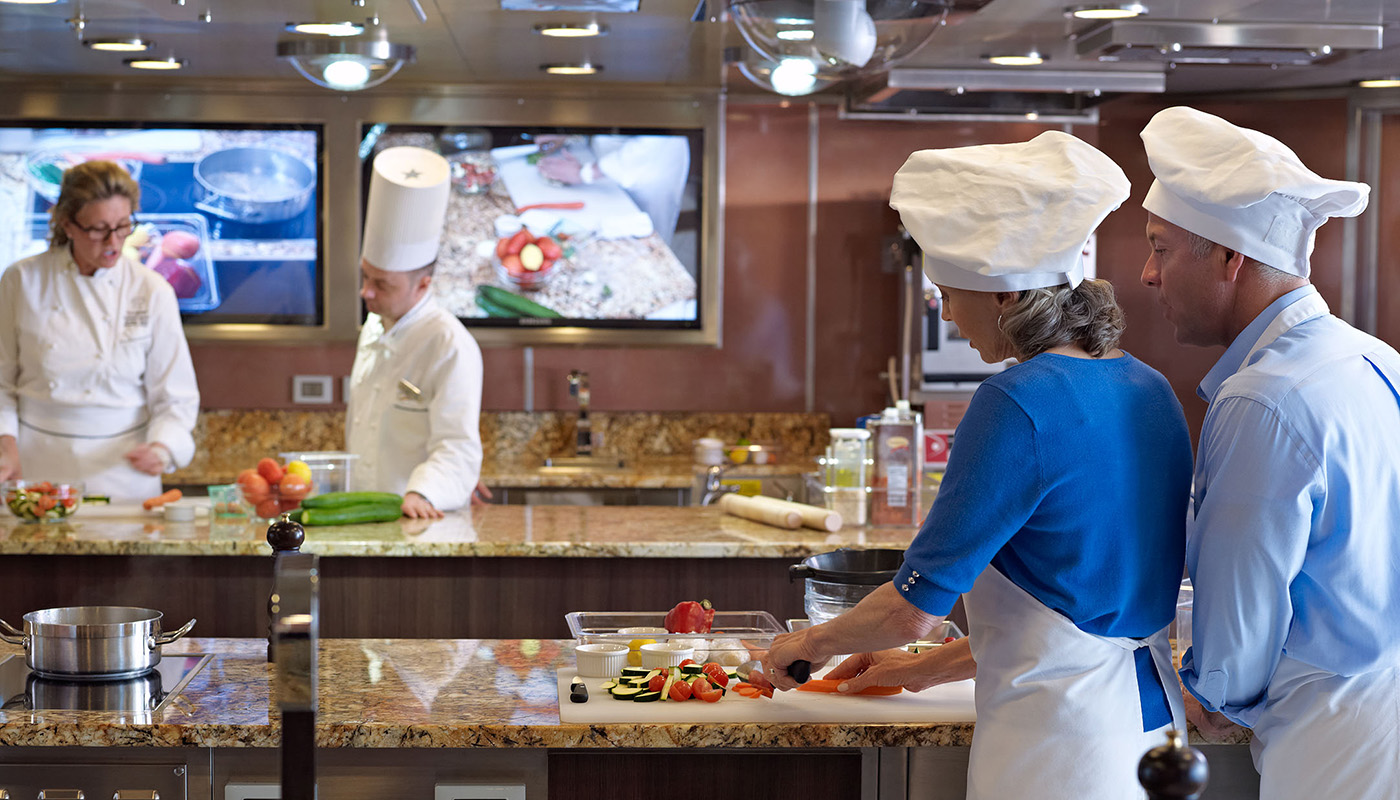 Man and woman onboard Oceania ship in culinary class with chefs