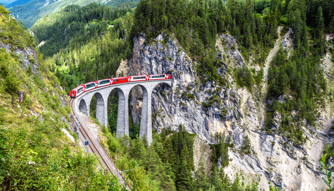 Glacier Express traveling through a Swiss mountain rail bridge